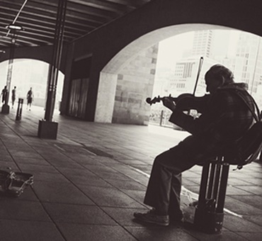 Man Playing Violin Under a Bridge