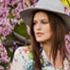 Woman Wearing Hat Infront of Flowers